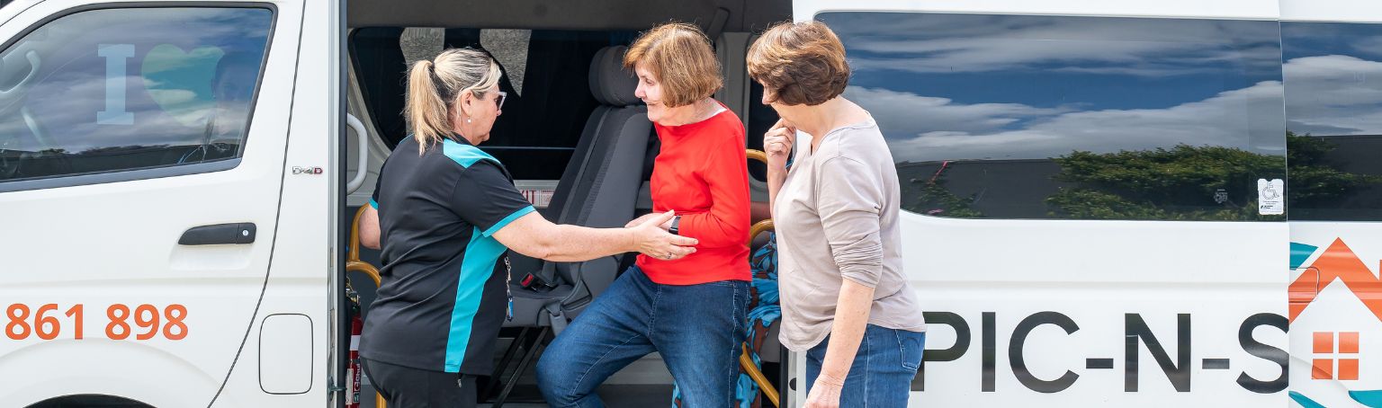 Support workers helping a participant into the Spic N Span van